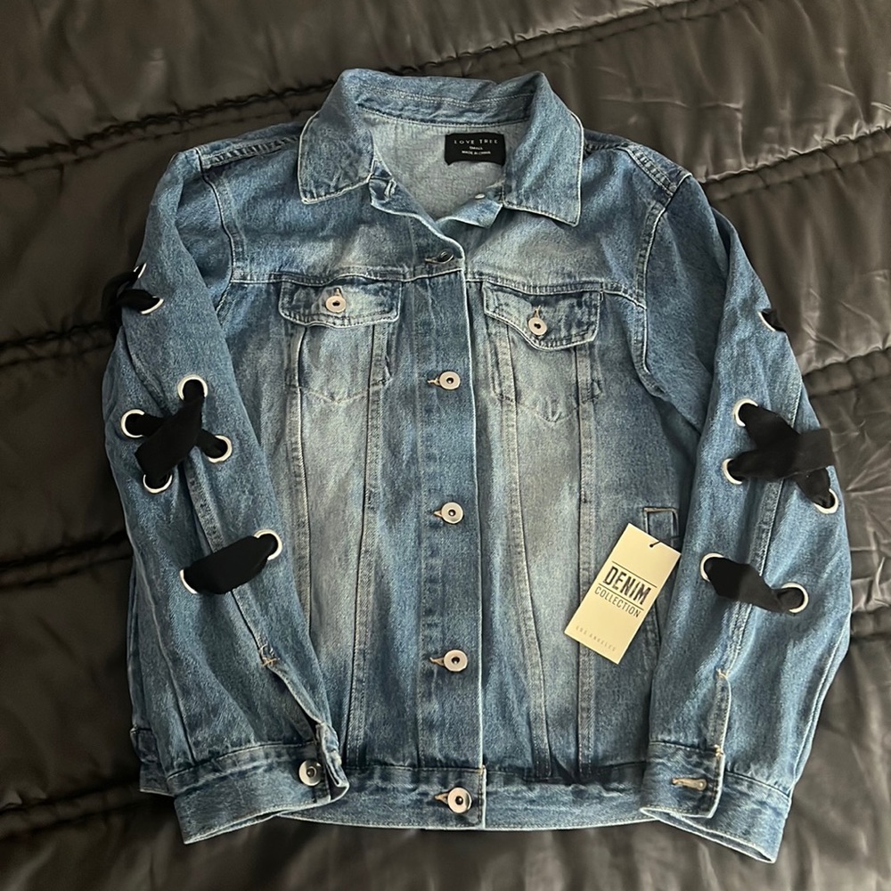 Never worn denim jacket with black criss-cross detailing across back